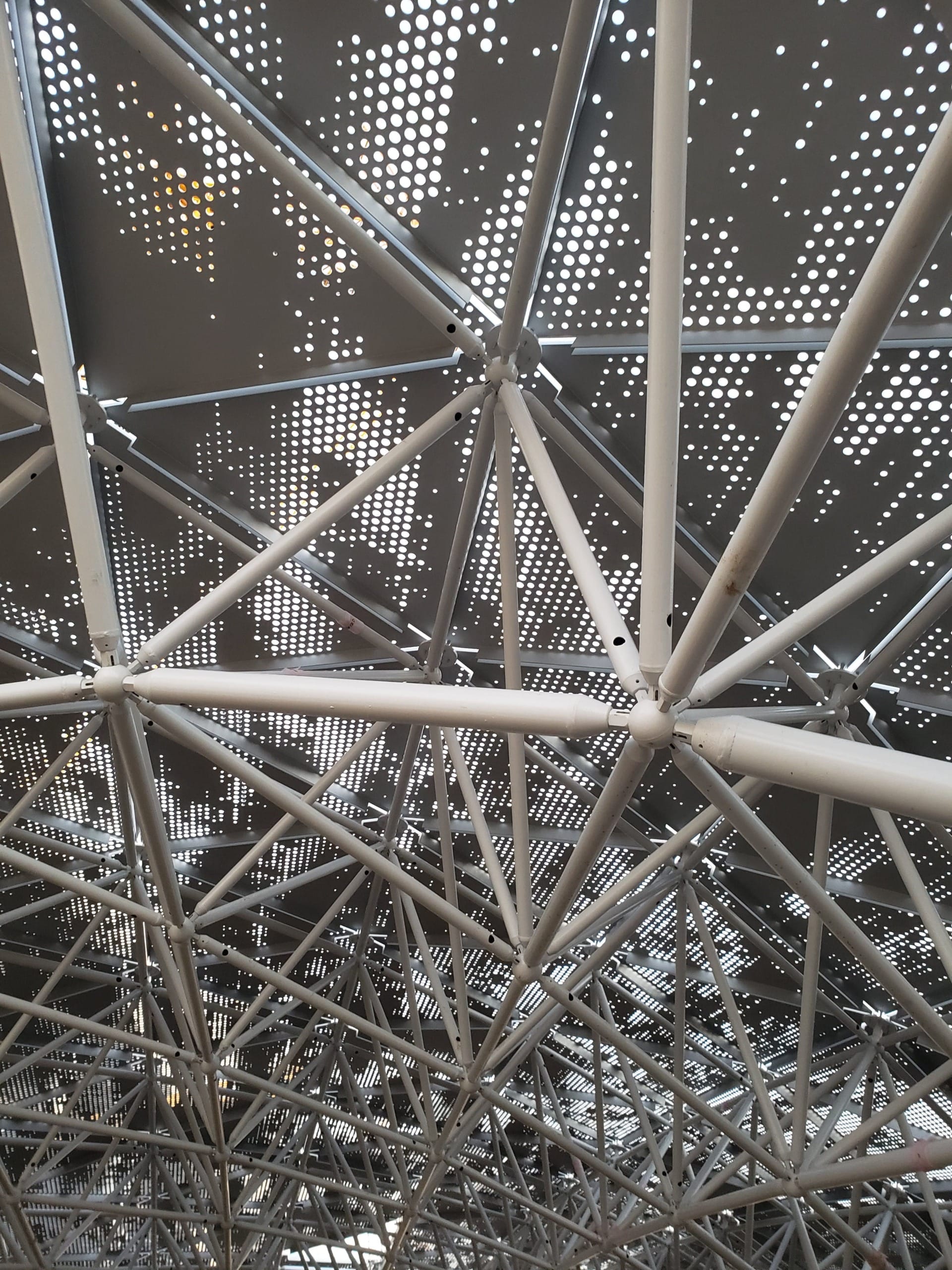 The triangular panels attach to a support system, which attaches to the steel structure surrounding the stadium.