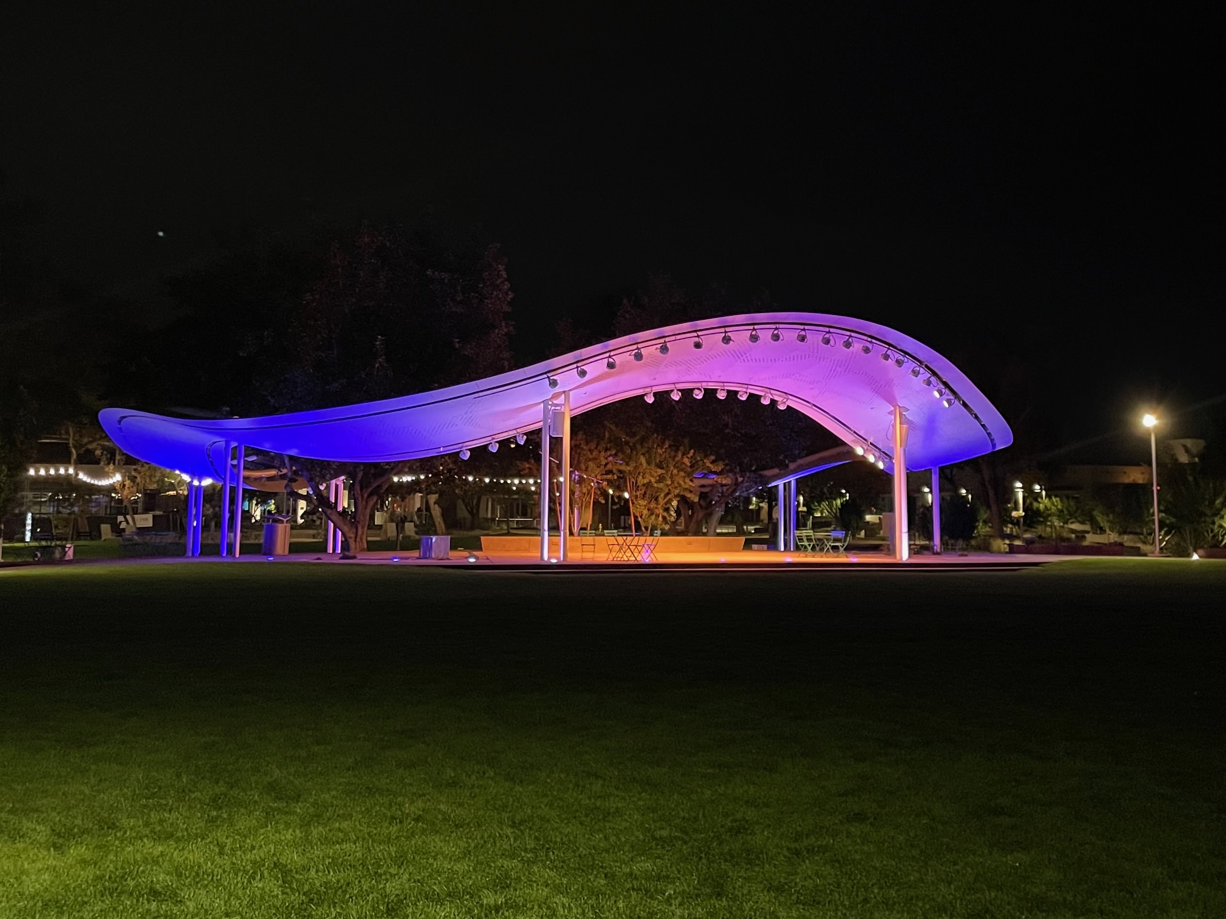 Lighting emphasizes the sculptural qualities of the pavilions at night.