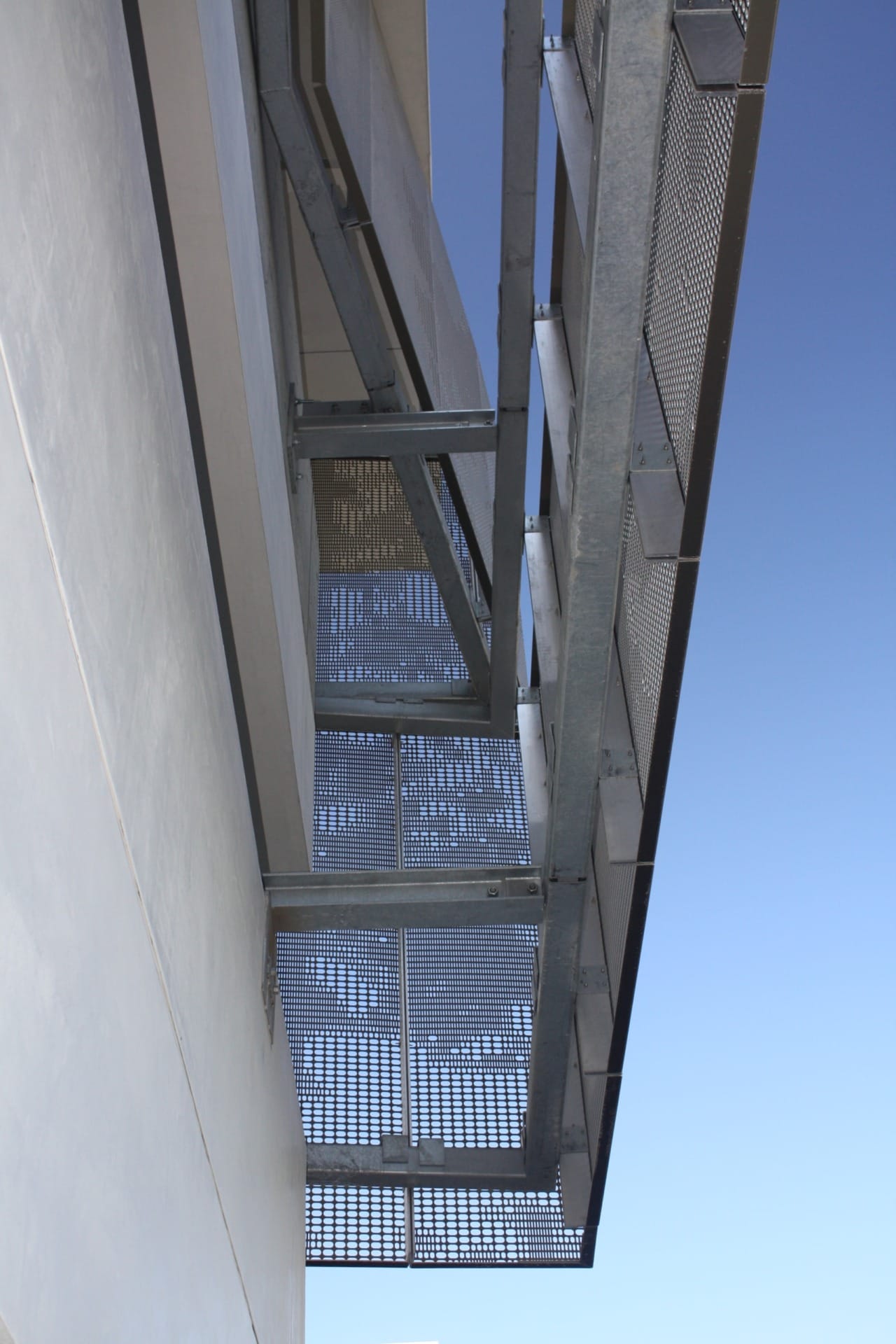 Detail of the perforated zigzag aluminum system used to cool and ventilate the school's parking garage.