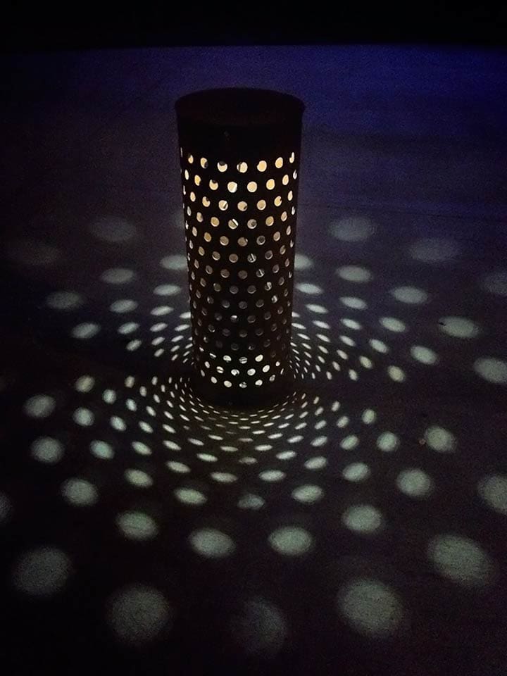 Custom cylinder sidewalk lights cast unique shadows through perforations.
