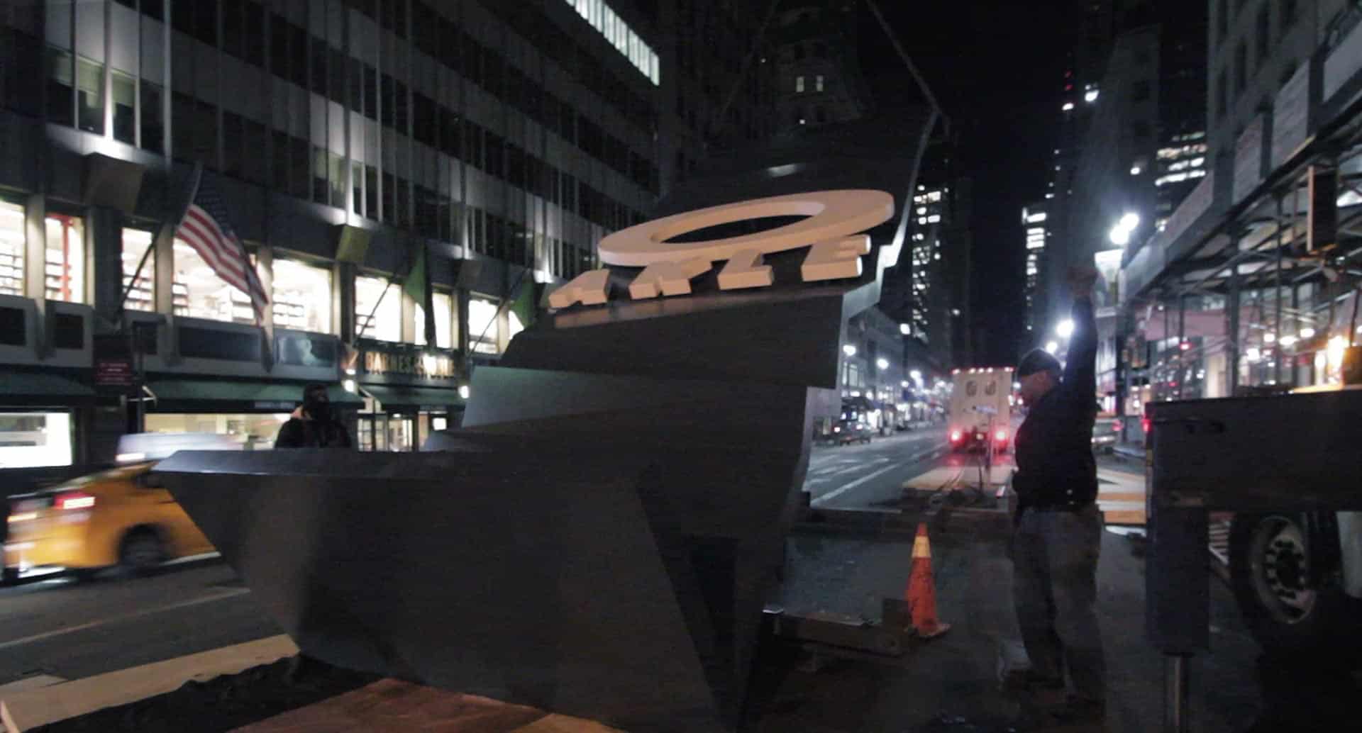 Installers lift the Oakley panel on Fifth Avenue in New York City.