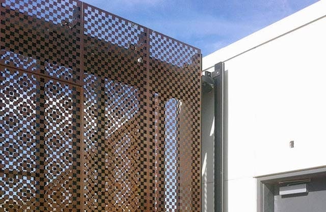 Quatrefoil moire pattern appears in the double-layered perforated metal.