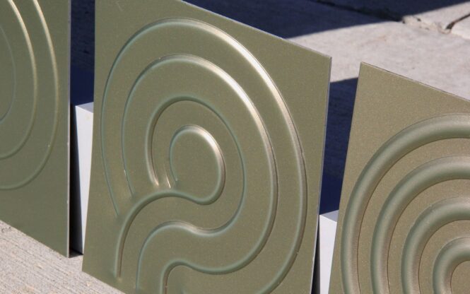 Embossed panel with offset wheel in color shifting coil coated aluminum